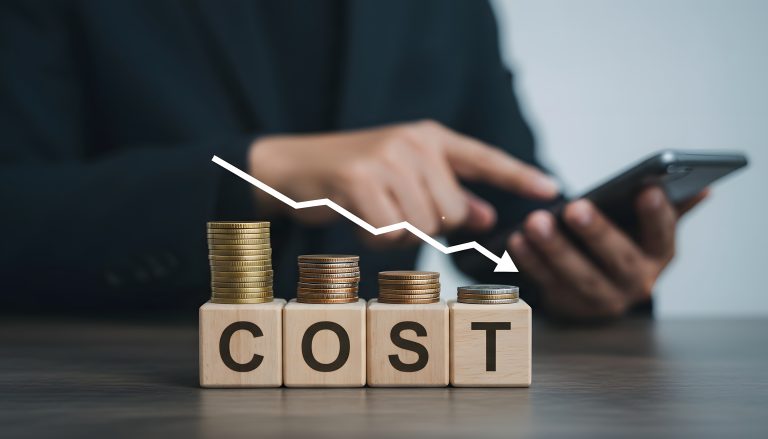 Business cost analysis with coins and wooden blocks on dark desk using smartphone